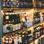 Schappen met verschillende craftbierflessen in een bar, met kleurrijke labels en warme verlichting die een gezellige sfeer creëren.