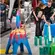 Child wearing blue helmet and NEMO employee stand in an arrangement of all kinds of objects that together form a chain reaction.
